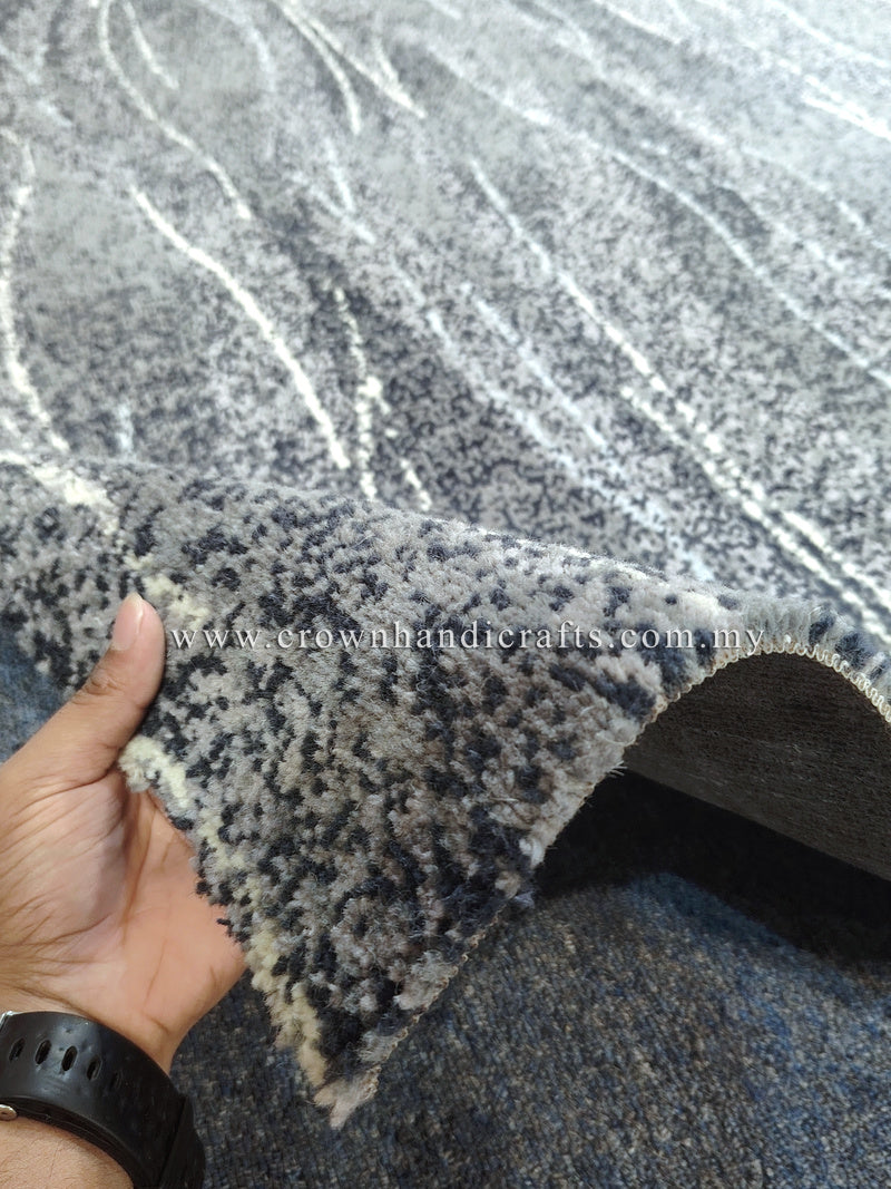 Abstract floor rug, dark blue-gray with light abstract lines; frayed corner edge.