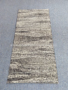 Beige abstract hallway runner rug with fine dark stripes, centered on floor