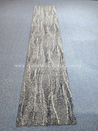 Long abstract runner rug with vertical wavy white lines on light gray background