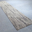 Long abstract runner rug with light gray and white streaked pattern
