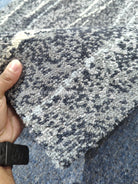 Long runner rug close-up with dark blue-gray and light speckled abstract pattern