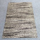 Abstract area rug with cream and black speckled horizontal stripes, flat view