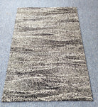 Abstract area rug with cream and black speckled stripe pattern, rectangular flat lay