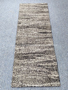 Runner rug: beige and black speckled abstract stripes, full view.