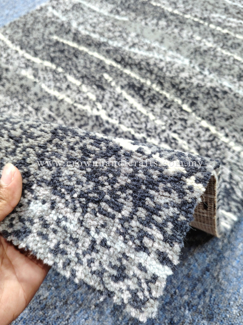 Runner rug: dark blue-gray speckled abstract horizontal bands, folded edge close-up.