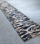 Narrow runner rug with zebra-like wave pattern in navy, cream, and light gray