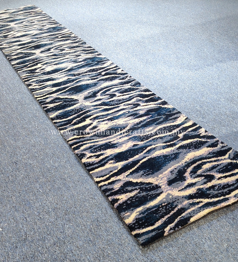 Narrow runner rug with zebra-like wave pattern in navy, cream, and light gray