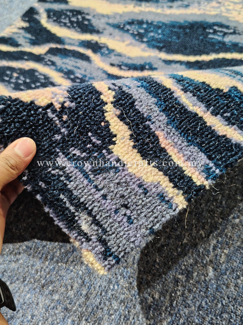 Textured wave-pattern runner rug, navy and cream, corner close-up with hand