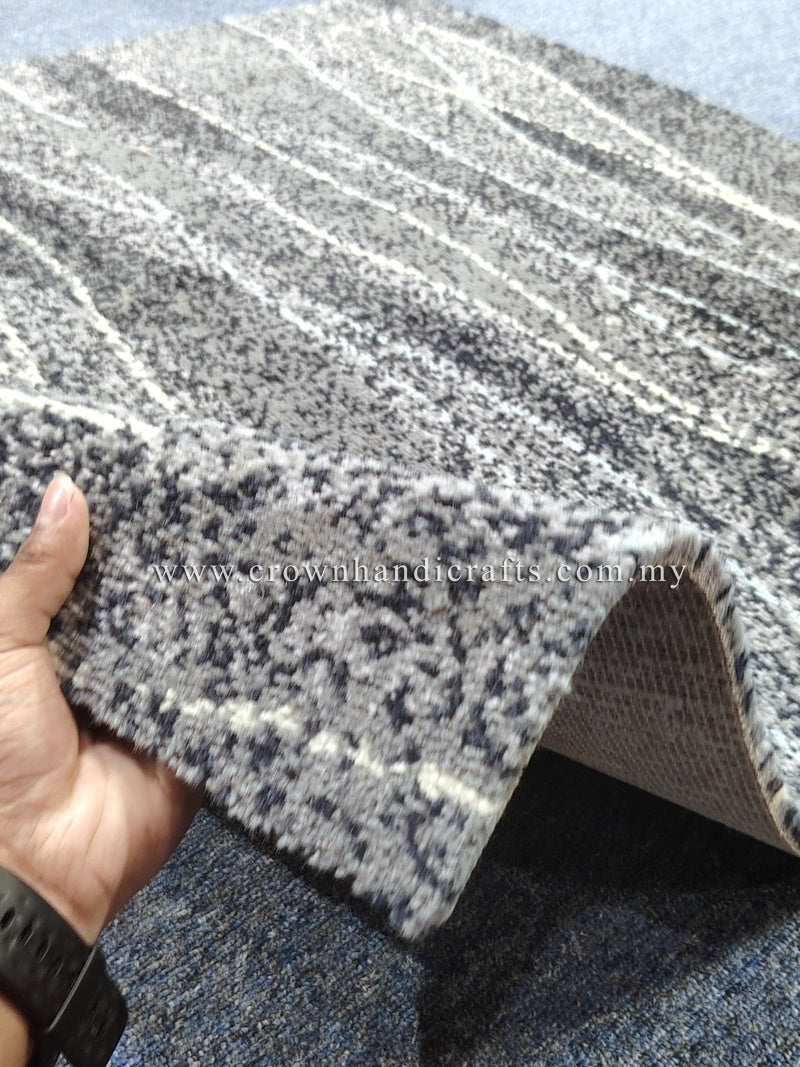 Abstract area rug with speckled navy and gray pattern, angled corner view