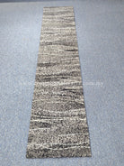 Slim runner rug featuring abstract horizontal stripes with speckled texture in gray