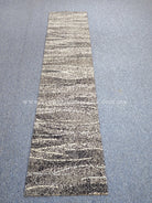 Narrow abstract runner rug with striped, speckled design in light and dark gray
