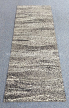 Hallway runner rug with beige and black speckled abstract horizontal stripe pattern