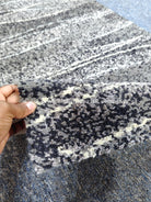 Hallway runner rug with dark blue, white, and speckled abstract stripe pattern, textured pile