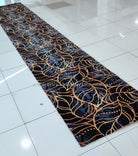 Navy blue runner rug with gold and light-blue swirling vine pattern, long hallway view
