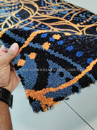 Dark blue runner carpet with gold and light-blue vine swirl pattern, textured pile close-up