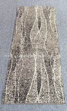 Abstract hallway runner rug with vertical stripe-like design in dark gray and ivory