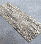 Abstract patterned hallway runner rug laid diagonally, speckled gray and white lines