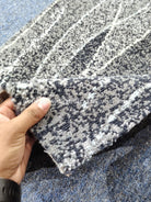 Abstract hallway runner rug with textured gray and white pattern, folded edge detail
