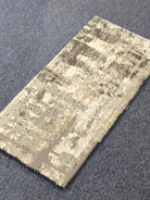 Compact grey mat rug, beige distressed lines and blocks with dark accents