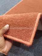 Rust velvet runner rug corner with braided edge and plush short pile