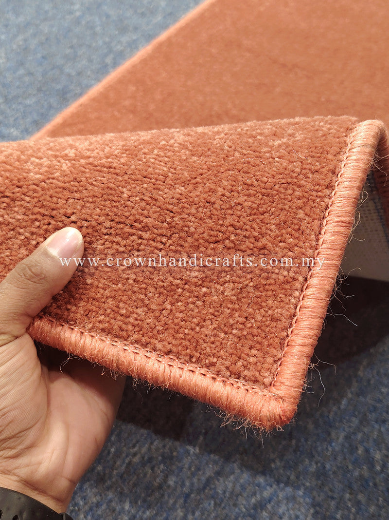Rust velvet runner rug corner with braided edge and plush short pile