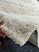 Cream area rug corner with short shag pile and stitched edge binding
