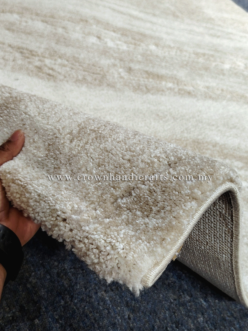 Cream area rug corner with short shag pile and stitched edge binding