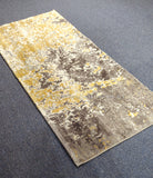 Two-tone runner rug with grey and yellow abstract distressed pattern, angled view