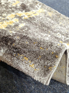 Two-tone runner rug with grey and yellow abstract distressed pattern, folded edge detail