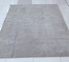 Plush square or rectangular area rug with short dense pile in light gray-beige