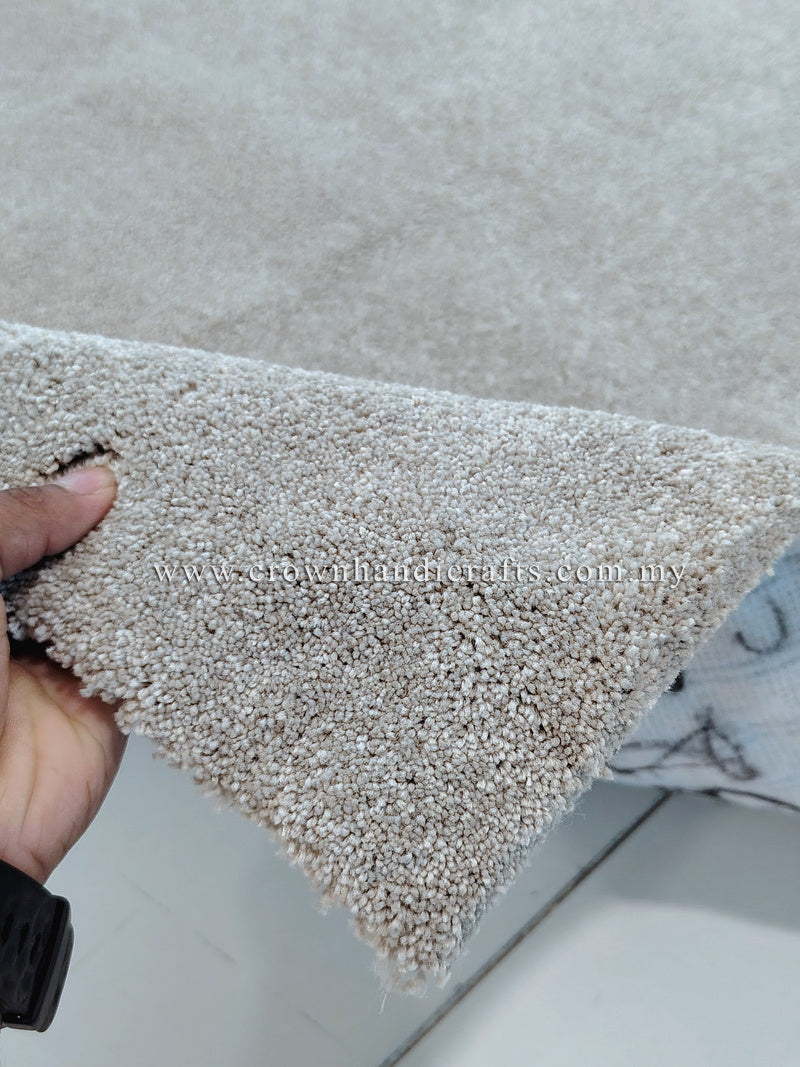 Plush area rug edge with short dense pile, light beige tone and rounded corner