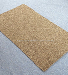 Rectangular brown-tan rug with fine speckled texture, flat lay on light floor