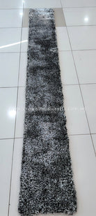 Monochrome shag runner rug, long narrow rug with dense black-and-white pile.