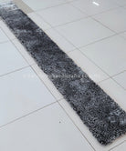 Black-and-white shag runner rug with dense texture, angled view.