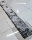 Thin black-and-white shag runner rug with speckled high-pile texture.