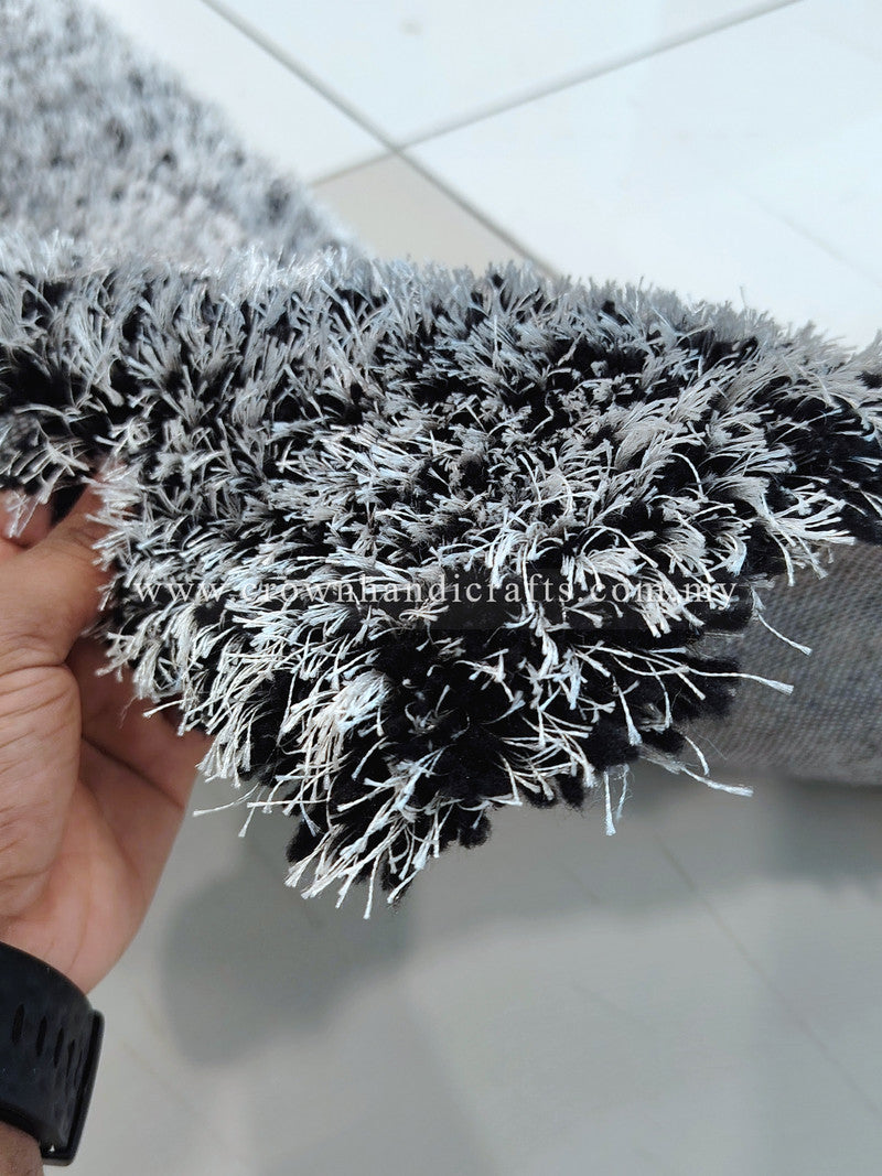 Shaggy runner rug close-up showing black-and-white tufted pile and fringe.