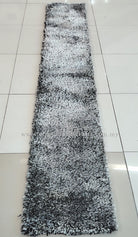 Long narrow shaggy runner rug with mottled black-and-white pile, full view