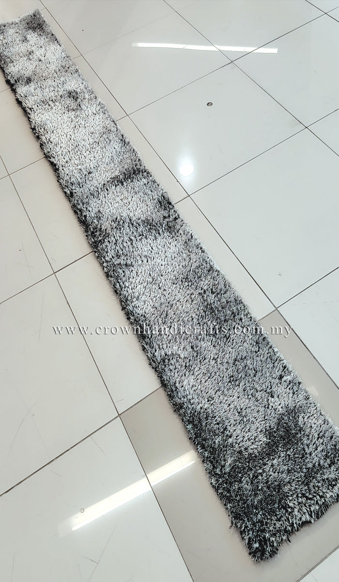 Narrow shaggy runner rug with mottled black-and-white texture, flat on floor