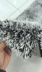 Shaggy runner rug, dense black-and-white pile, close-up of fringed edge