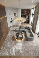 Large abstract area rug with worn beige and white motif, stitched border.