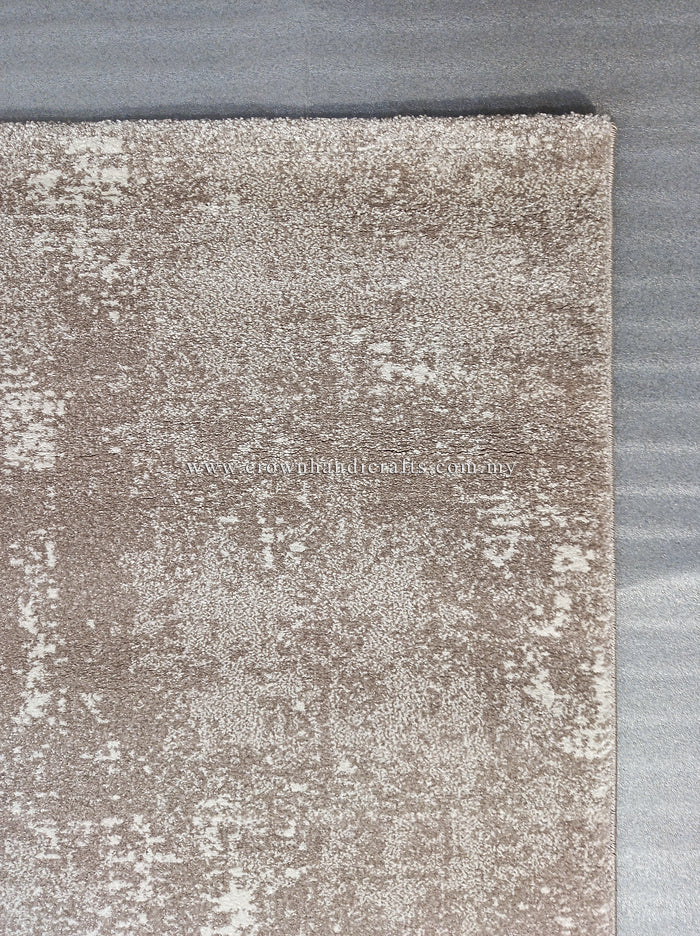 Abstract area rug with distressed beige and white pattern and stitched edge.