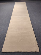 Beige runner rug on a dark gray floor
