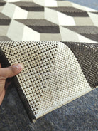 Woven runner rug corner with cream and dark brown checker-cube pattern