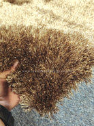 Shaggy brown multi-tone runner rug pile close-up with fingers touching