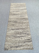 Beige abstract runner carpet with horizontal stripe bands and dark speckled weave, full view.