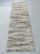 Beige and dark speckled abstract runner carpet with horizontal stripe bands, flat view.