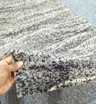 Abstract runner carpet edge detail, beige with dark speckled dots and striped motif.