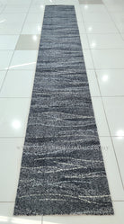 Long abstract runner rug laid flat, dark blue-gray abstract stripes and speckled highlights