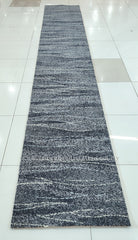 Long abstract runner rug, dark blue-gray with speckled texture and fine horizontal streaks