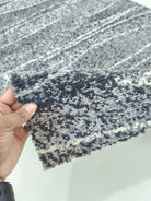 Abstract runner rug corner detail, dark blue-gray with dotted texture and horizontal lines